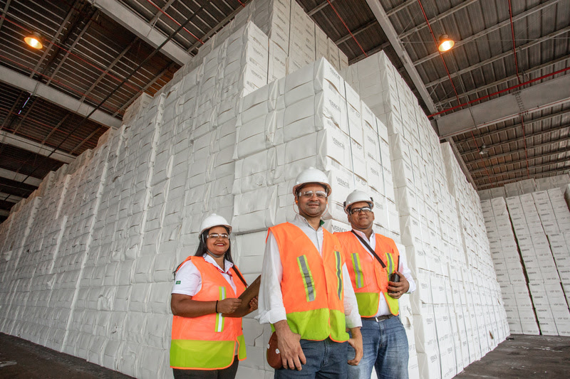 Equipe da Veracel em frente aos fardos de celulose já emabalados na fábrica, prontos para serem transportados. (Foto: Quélvin Clécio)